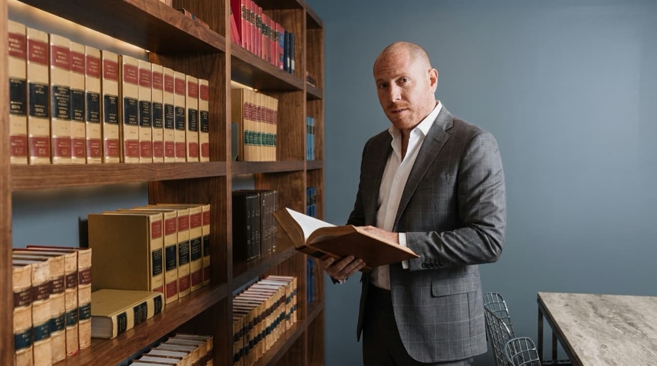 Samuel Bissu revisando un tomo en la biblioteca jurídica del despacho