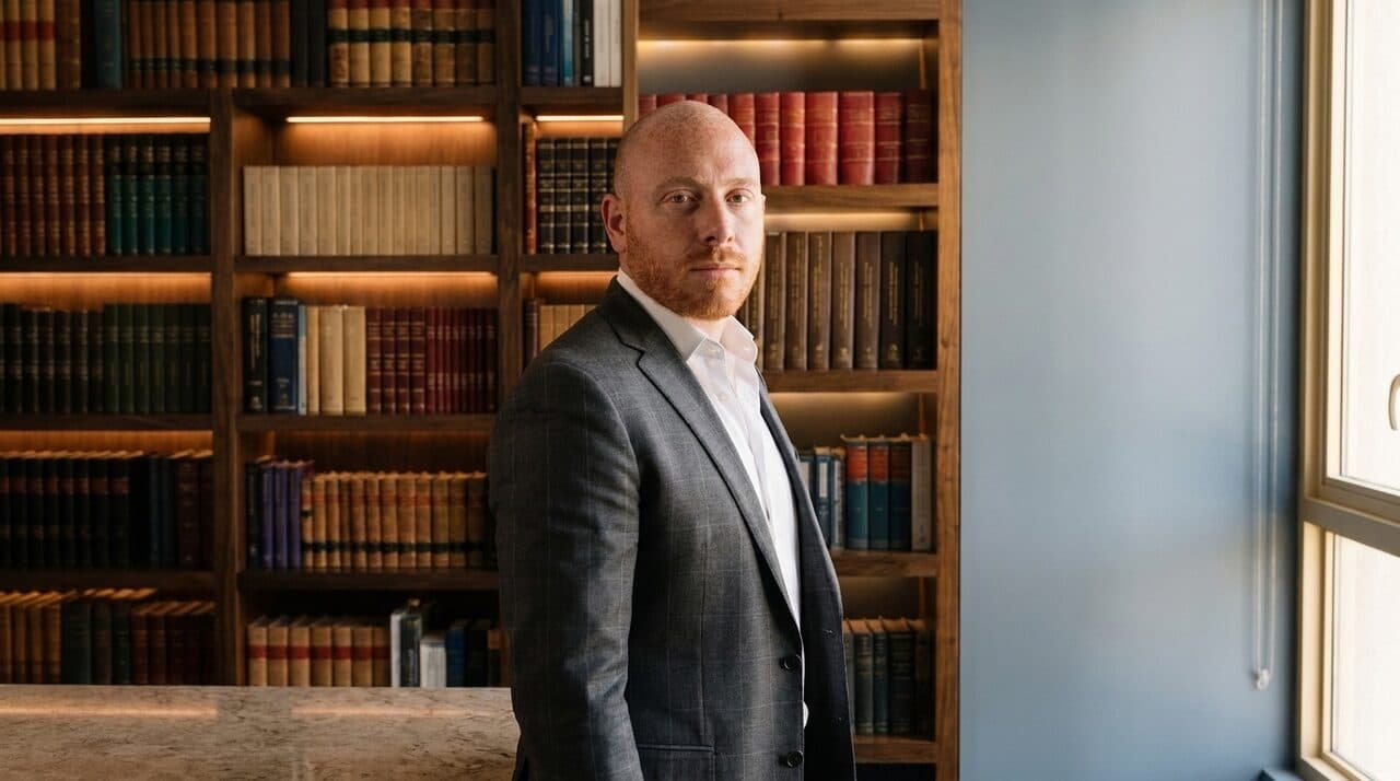 Samuel Bissu de pie en la biblioteca juridica del despacho